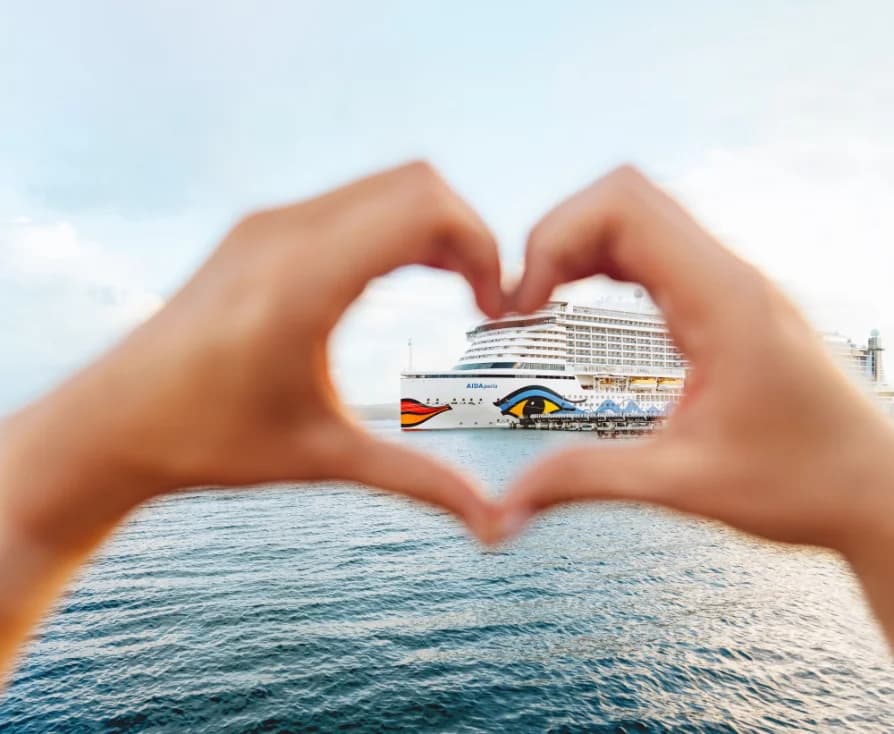 Kreuzfahrtschiff, mit den Händen zu einem Herz eingerahmt